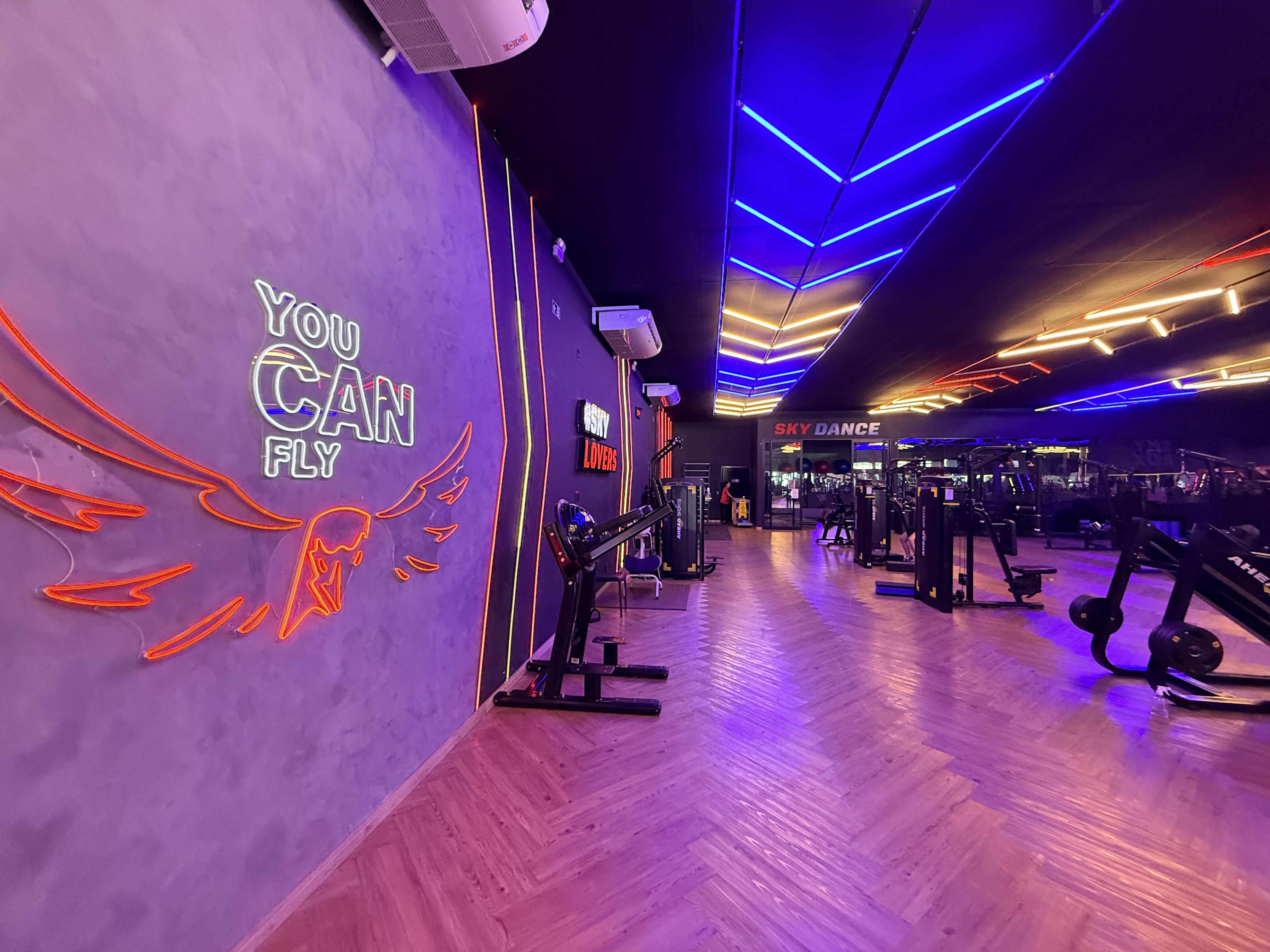 Corredor da Skyfit Boituva com decoração neon e acesso às salas